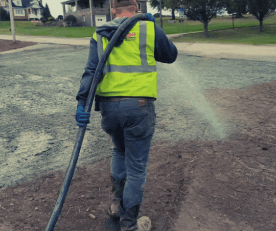 TruScape crew applying hydroseed slurry with a hose
