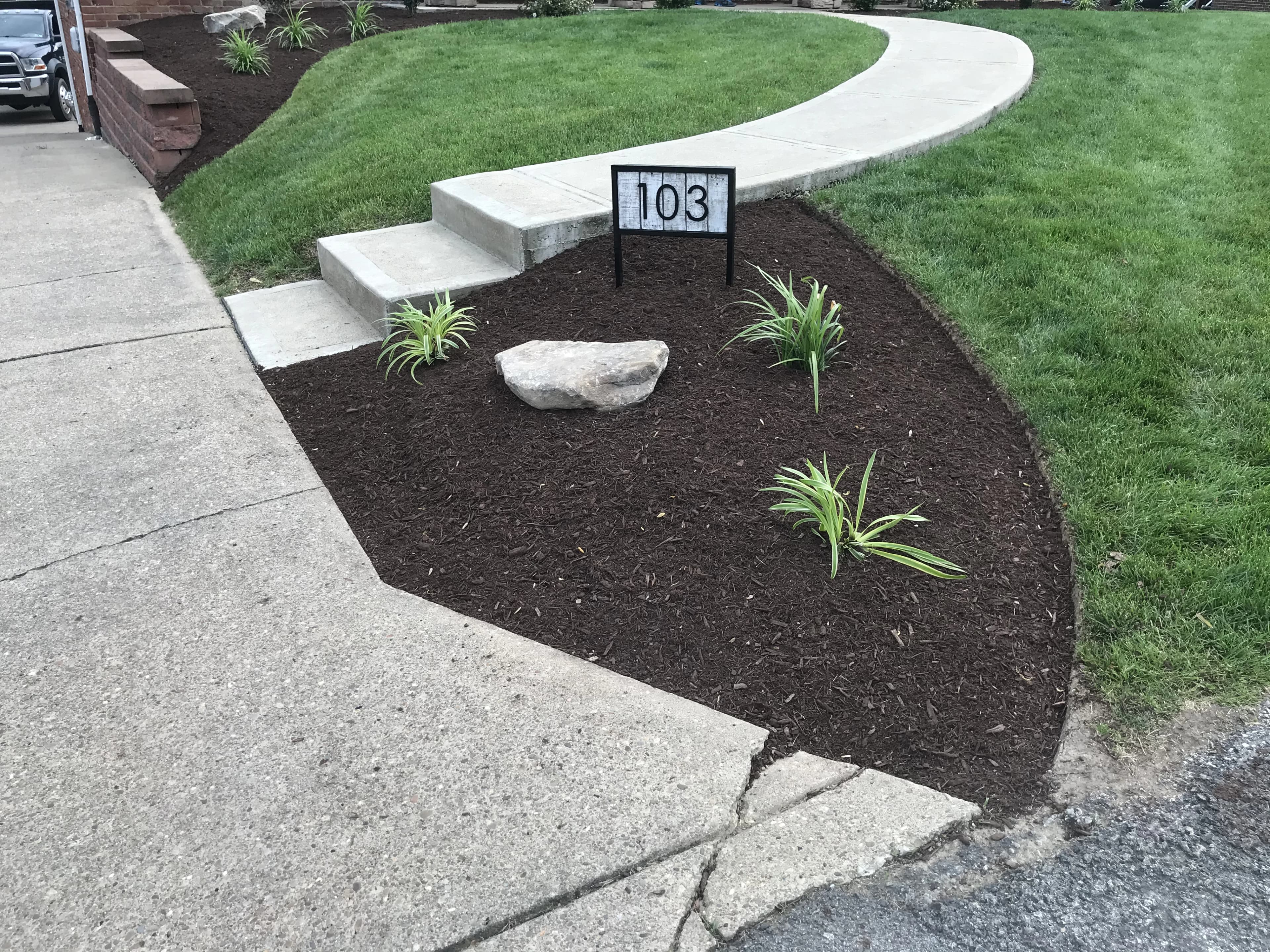 Mulched landscape bed with decorative stone border